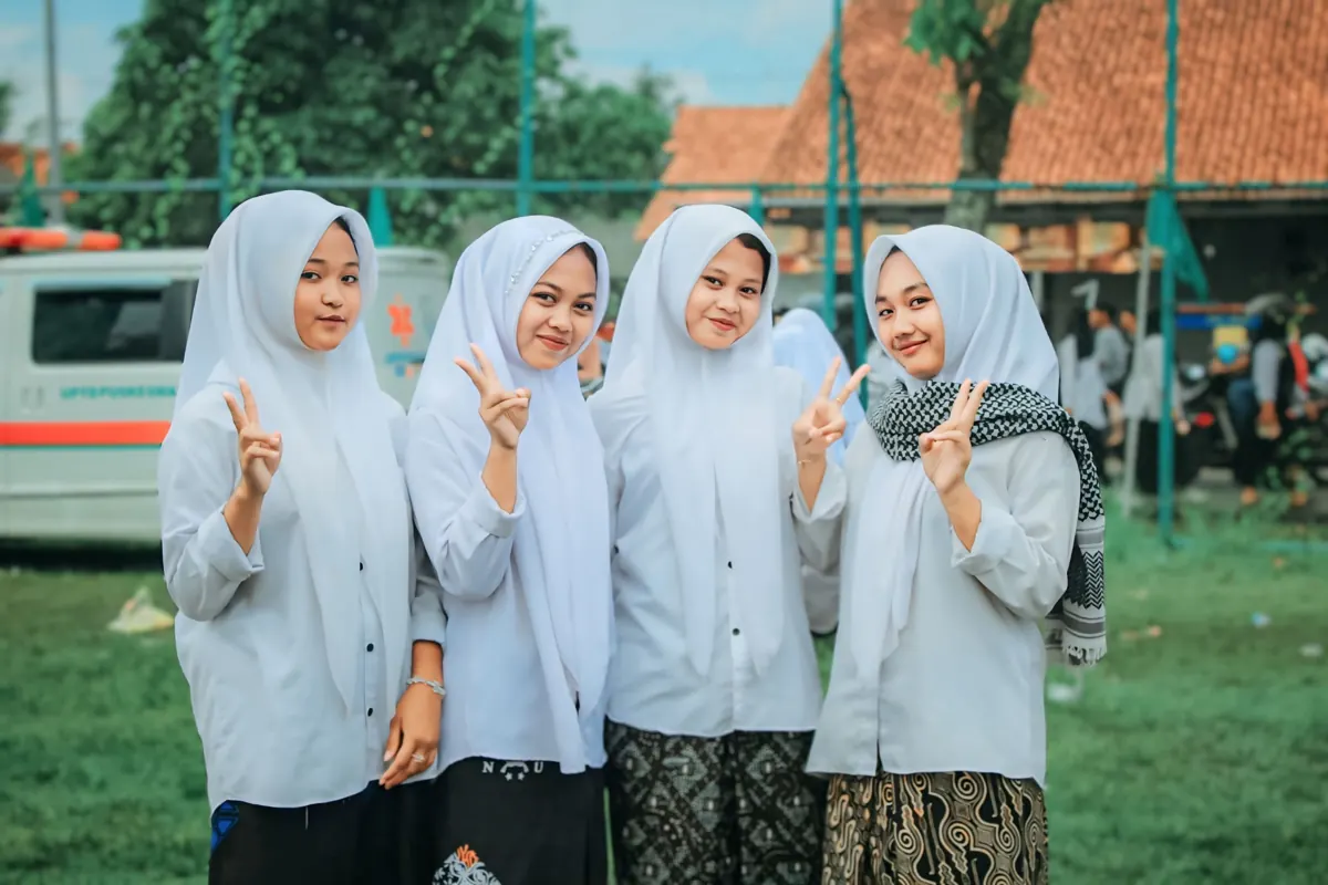 Empat santri putri tersenyum di halaman pondok